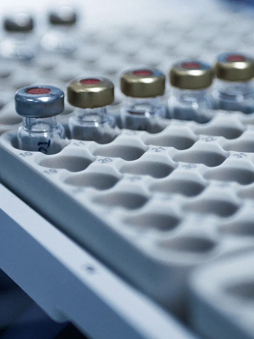 Close-up of glass vials on a filling-line tray